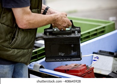 A Senior Man Recycling A Car Battery