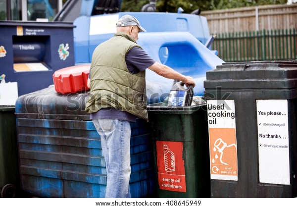 A senior man\
recycling an empty oil\
container
