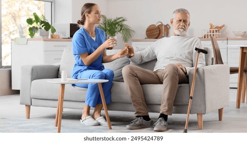 Senior man refusing to take pill from nurse at home - Powered by Shutterstock