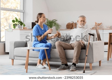 Senior man refusing to take pill from nurse at home