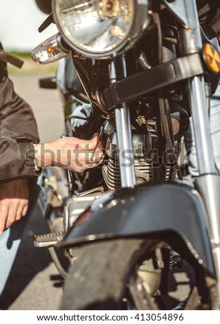 Senior man repairing damaged motorcycle engine