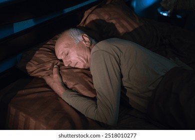 Senior man resting peacefully in his cozy bed at night after a long day. He enjoys a quiet and comfortable sleep in the tranquility of his room, recharging for the next day. - Powered by Shutterstock