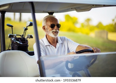 Senior Man Riding Golf Car.