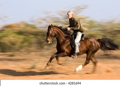 Senior Man Riding The Horse In The Bush, Panning Shot.