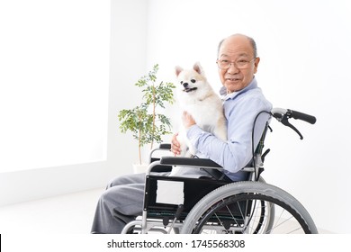 Senior Man Riding In A Wheelchair Keep A Dog