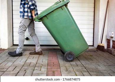 Senior Man Rolling Garbage Can
