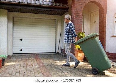 Senior Man Rolling Garbage Can
