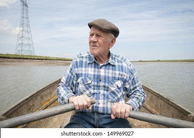 Senior man rowing a boat on a reservoir - Powered by Shutterstock