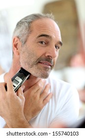 Senior Man Shaving Beard With Electric Razor