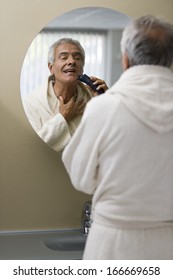 Senior Man Shaving In Front Of The Mirror