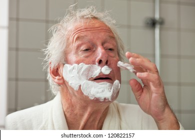 Senior Man Shaving His Beard In Bathroom.