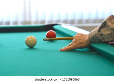 Senior Man Shooting A Game Of Pool