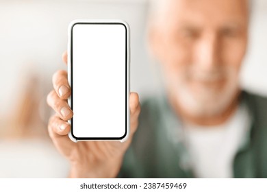 Senior man showing blank smartphone with empty white screen to camera, elderly gentleman recommending mobile website or app, demonstrating cellphone display, selective focus, mockup - Powered by Shutterstock