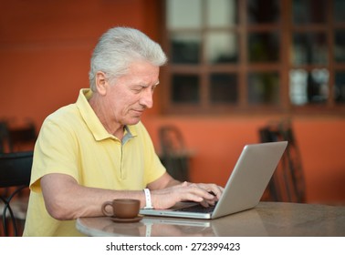 Senior Man Sitting With Laptop In Hotel