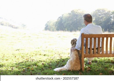 Senior Man Sitting Outdoors With Dog
