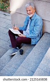 A Senior Man Sitting Outside And Writing To Do List.