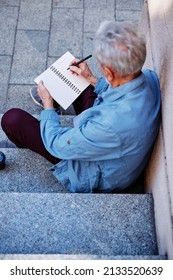 A Senior Man Sitting Outside And Writing To Do List.