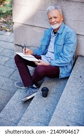 A Senior Man Sitting Outside And Writing To Do List.