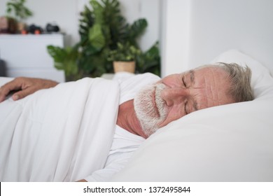 Senior Man Sleeping Alone And Headache Or Dreaming Nightmare On Bed In Room