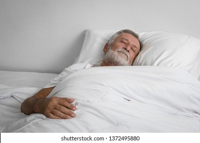 Senior Man Sleeping Alone On Bed In Room