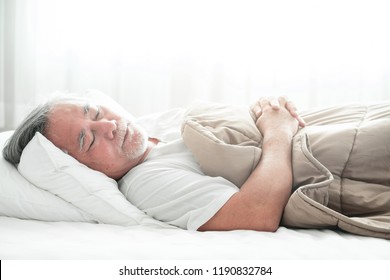 Senior man sleeping in bed. Old asian man sleeping comfortably in bed with curtain open. Senior lifesyle concept.