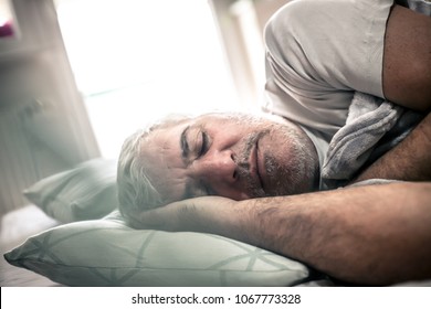 Senior Man Sleeping In Bed. Space For Copy.