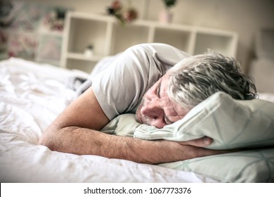 Senior Man Sleeping In Bed. Space For Copy.