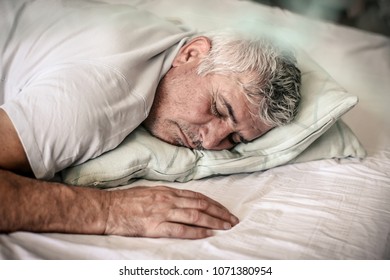 Senior Man Sleeping In Bed. Space For Copy.