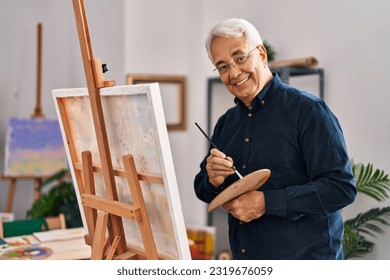 Senior man smiling confident drawing at art studio - Powered by Shutterstock