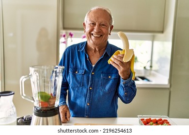 Senior man smiling confident holding peeled banana at kitchen - Powered by Shutterstock