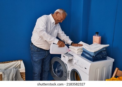 Senior man smiling confident pouring detergent on washing machine at laundry room - Powered by Shutterstock