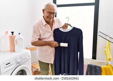 Senior Man Smiling Confident Using Clean Pet Hair Roller At Laundry Room