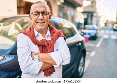 Senior man smiling happy standing over car at the city.