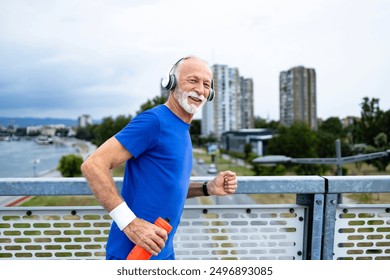 Senior man smiling while running over the bridge. Healthy lifestyle.