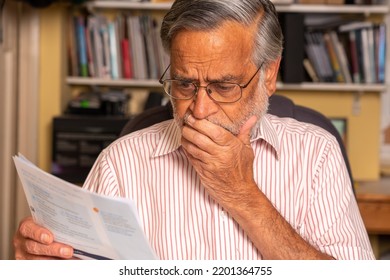 A Senior Man Of South Asian Origin Looks At His Bill And Appears Shocked