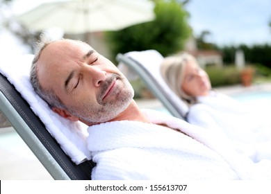 Senior Man In Spa Hotel Relaxing In Long Chair