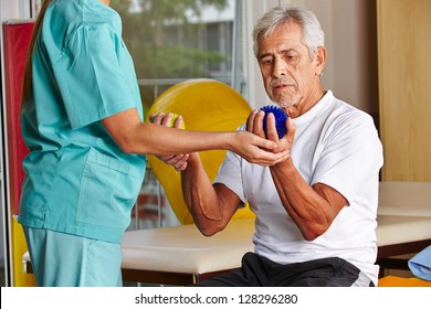 Senior man with spikey balls in gym with physiotherapist