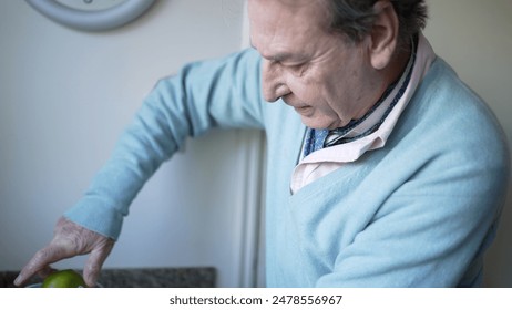 Senior Man Squeezing Lime in Kitchen for Fresh Juice, Focused and Detailed Preparation Emphasizing Healthy Living - Powered by Shutterstock