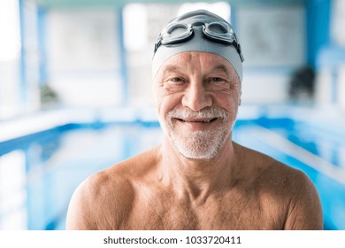 Senior Man Standing In An Indoor Swimming Pool.