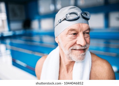 Senior man standing in an indoor swimming pool. - Powered by Shutterstock