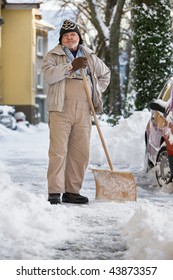 Senior Man Standing With Snow Shovel