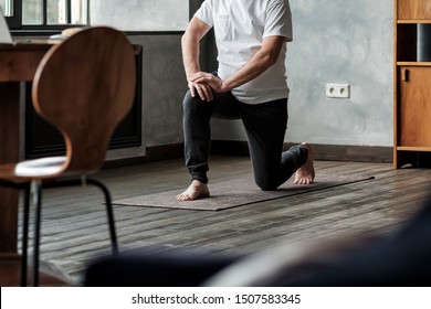 Senior Man Standing In Warrior Yoga Pose Variation Practicing In Living Room Alone. No Face View.