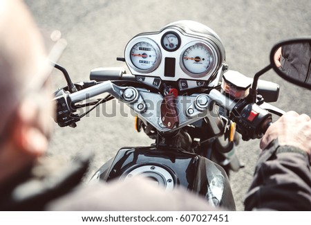 Senior man steering motorcycle on road