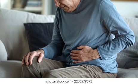 Senior man with stomach pain - Shutterstock ID 2238579371