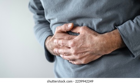 Senior man with stomach pain - Shutterstock ID 2239942249