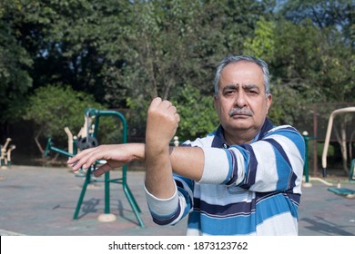 Senior man stretches hands before exercise