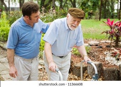 Senior Man Struggling To Us A Walker.  His Adult Son Is Helping Him.