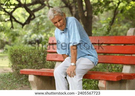 Senior man suffering from knee pain at park. Pain In The Elderly, Health care