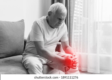 Senior Man Suffering From Pain In His Knee At Home. Concept Of Problems With Joint Like Arthritis.