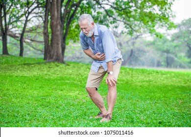 Senior man suffering from sick stomach or stomachache and vomiting outdoor in garden park . old elderly male drunk hangover and puke